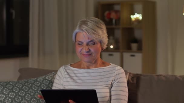 mujer mayor feliz con la tableta PC en casa por la noche
 - Metraje, vídeo