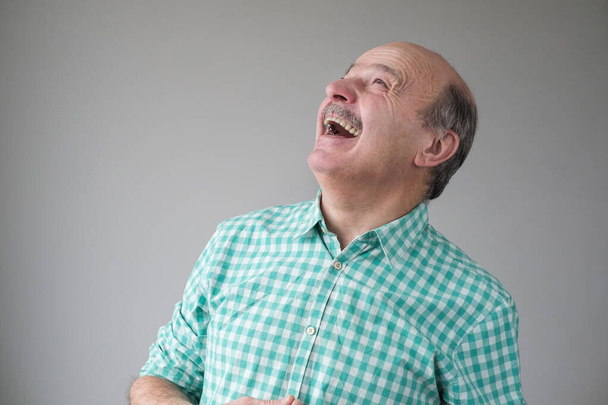 Kale volwassen latino man kijkt op naar lachen. - Foto, afbeelding
