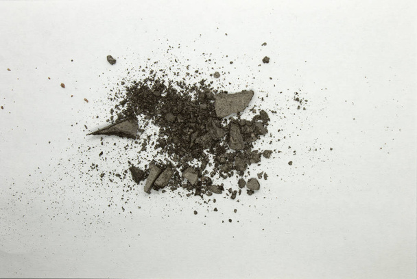 Dies ist eine Fotografie eines graubraun schimmernden Puder-Lidschatten isoliert auf weißem Hintergrund - Foto, Bild