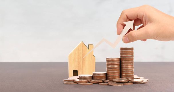 Wooden toy house Mortgage property home concept. coins in hand B - Foto, afbeelding