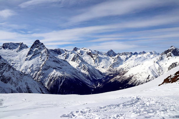 Сніжні гори здіймаються на блакитному небі Кавказу. - Фото, зображення