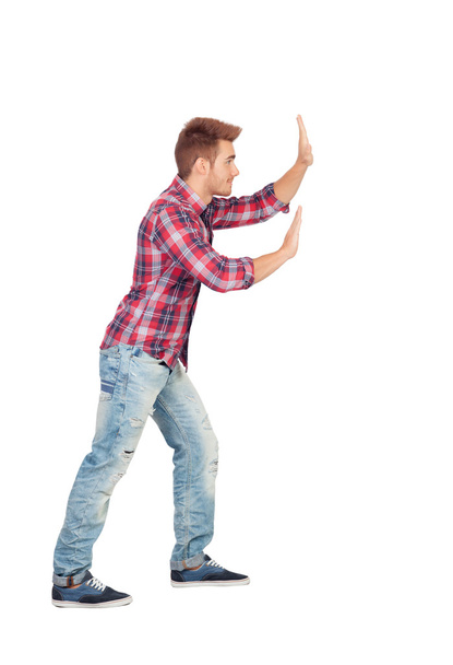 Young man with plaid shirt pushing - Photo, Image