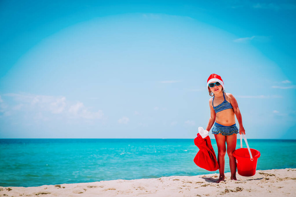 schattig klein meisje vieren kerst op tropisch strand - Foto, afbeelding