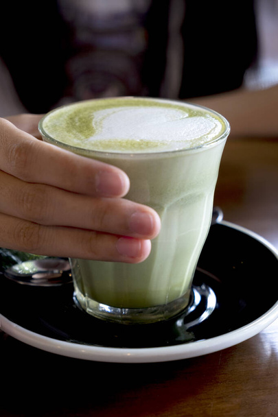 Gorąca zielona herbata latte na drewnianym blatem - Zdjęcie, obraz