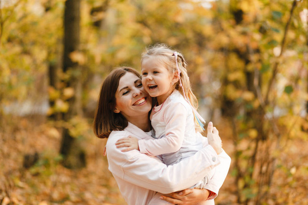 Usmívající se portrét matky a dcery v podzimním parku - Fotografie, Obrázek