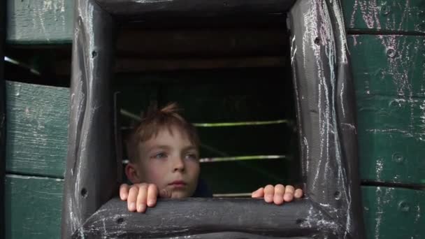 A fiú kimászik az ablakon, és távcsövön keresztül néz. - Felvétel, videó
