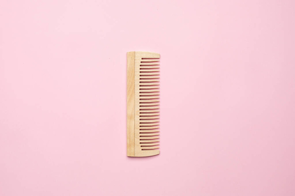 Eco wooden comb on pink background , bathroom and hair accessory - Фото, зображення