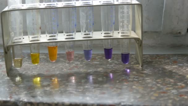 Gekleurde reageerbuizen in het laboratorium op een oud raam met marmeren vensterbank. - Video