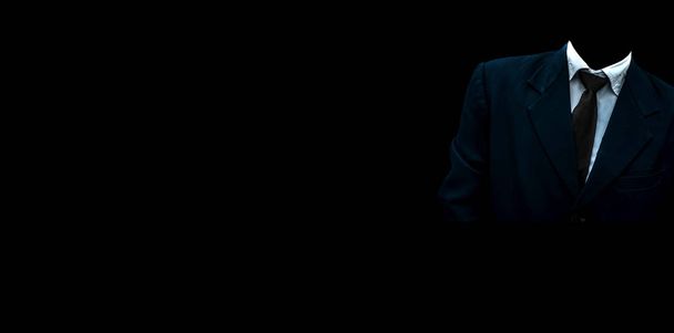 Homem irreconhecível sem rosto vestindo um terno de cor azul com uma gravata preta e de pé contra um fundo preto com boa atitude positiva. Imagem de grande ângulo de resolução total
. - Foto, Imagem