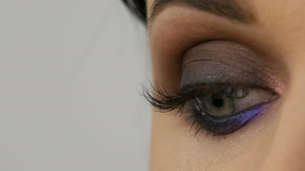 Hermosa noche costosa elegante maquillaje ojos ahumados de gris inusual y azul sombra de ojos. Hermosos ojos azules femeninos vista de cerca
 - Metraje, vídeo