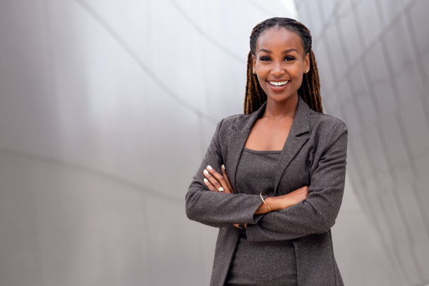 Bonita pessoa de negócios afro-americana de pé confiante com orgulho, sucesso, sorriso realizado no distrito financeiro
 - Foto, Imagem
