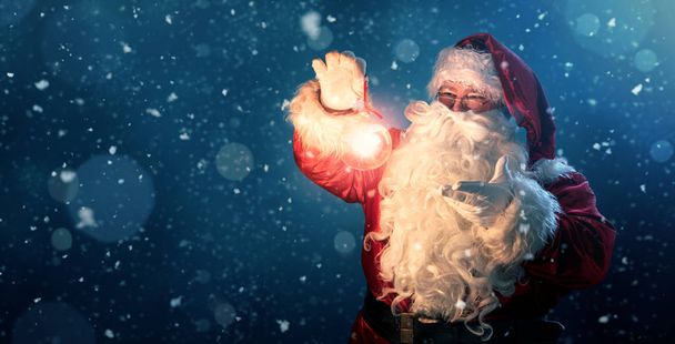 Ευτυχισμένος Άγιος Βασίλης κρατώντας λαμπερό χριστουγεννιάτικη μπάλα - Φωτογραφία, εικόνα