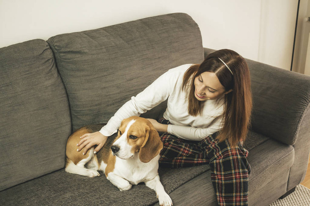 Giovane donna con il suo cane a casa allenatore
 - Foto, immagini