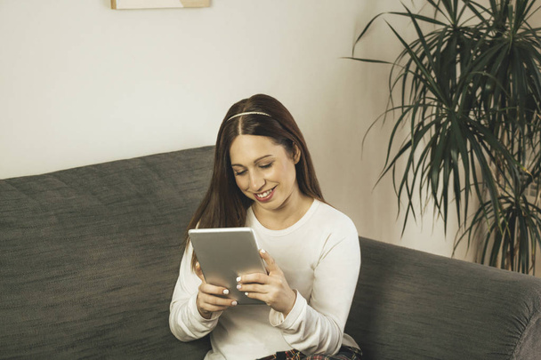 Mujer joven usando su tableta en casa entrenador
 - Foto, Imagen