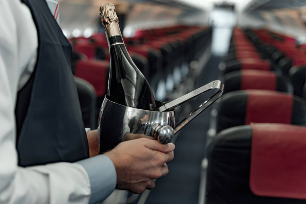 Air steward standing with champagne for passengers - Zdjęcie, obraz