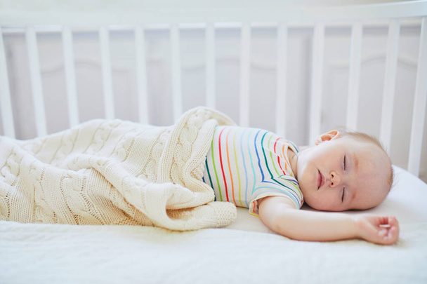 Baby sleeping in co-sleeper crib attached to parents' bed - Photo, Image