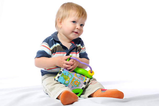 Toddler plays with loved toy holding plush ball - Foto, immagini