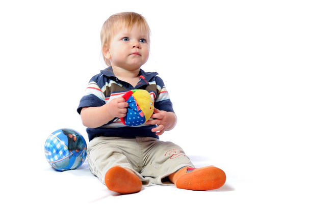 Toddler plays with loved toy holding plush ball - Zdjęcie, obraz