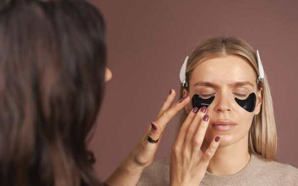makijaż artysta stosując hydrożel przepaski na oczy na kobieta blondynka top model przed makijaż - Zdjęcie, obraz