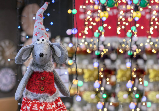 Topo giocattolo in vestiti lavorati a maglia sullo sfondo di ghirlande festive. Simbolo del 2020
. - Foto, immagini