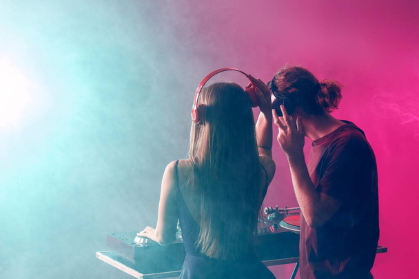 Młodzi DJ-e grający muzykę w nocnym klubie - Zdjęcie, obraz