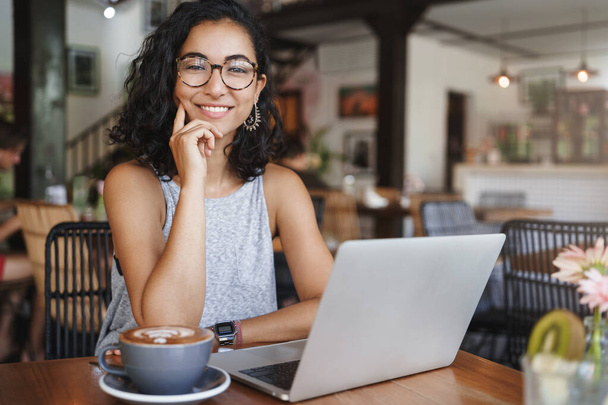Business, corporate and recruitment concept. Cheerful good-looking female freelancer, young hipster girl student sit coworking place, cafe, smiling as using laptop and drink coffee, hr having meeting - Foto, Imagem