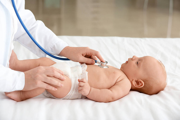 Pediatrician examining cute baby in clinic - Photo, Image
