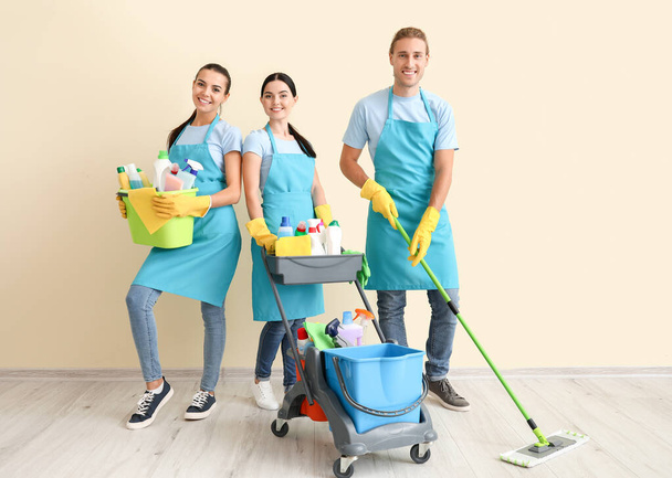 Janitors with cleaning supplies near light wall - Foto, Imagem