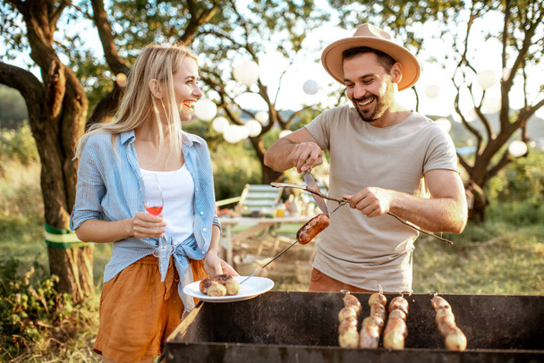 Couple having barbecue in the garden - Photo, Image