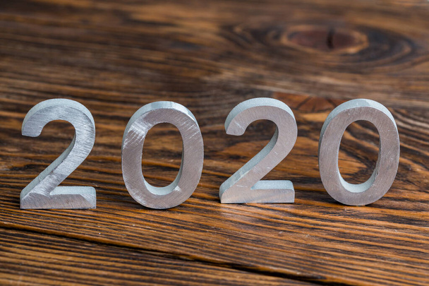 число 2020 с белыми металлическими цифрами на темно-коричневом фоне дерева с избирательным фокусом
 - Фото, изображение