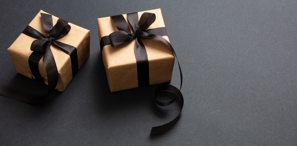 Gifts with black ribbon against black background, Black Friday concept. - Foto, immagini