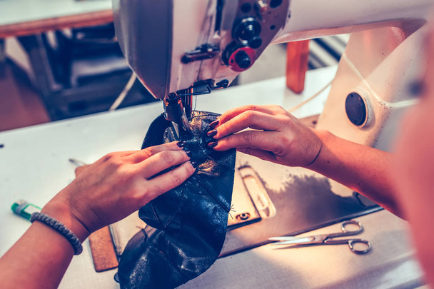 Manos de una costurera experimentada cosiendo una parte del zapato
  - Foto, imagen