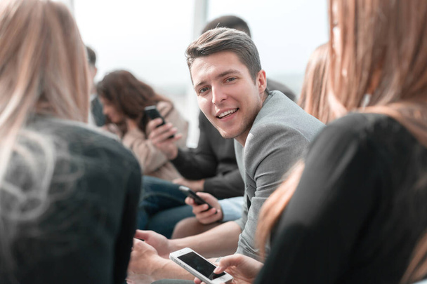 smiling guy sitting in a circle at a group meeting - Foto, Imagen