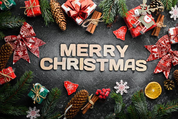The banner with the words "Merry Christmas". Top view. On a black stone background. - Zdjęcie, obraz