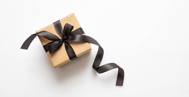 Caja de regalo con cinta negra aislada sobre fondo blanco, concepto Black Friday
. - Foto, imagen