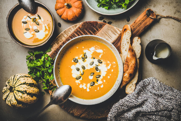 Flat-lay of pumpkin soup with seeds, fresh parsley and cream - Foto, Imagem