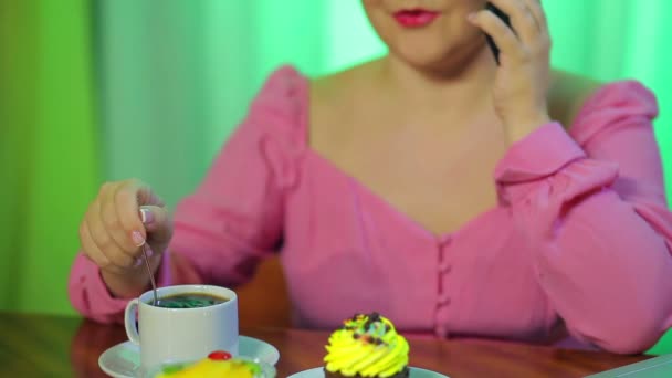 a married Jewess in a cafe bothers with a spoon of coffee and talks on the phone - Felvétel, videó