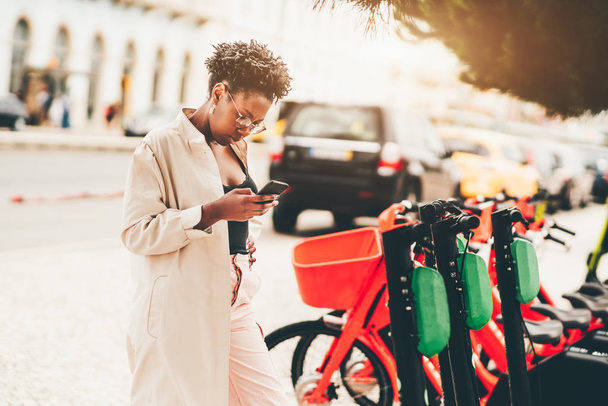 Chica negra está activando e-scooter
 - Foto, Imagen