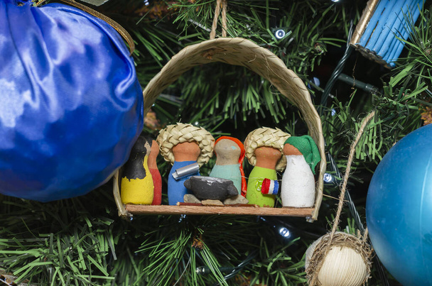 Decorações artesanais para árvore de Natal, palhas palhas de cerâmica, nascimentos de Jesus em vermelho branco e azul. Virgem Maria San Jose
 - Foto, Imagem