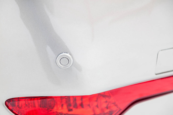 Um sensor de estacionamento cinza no pára-choques de um belo carro underne
 - Foto, Imagem
