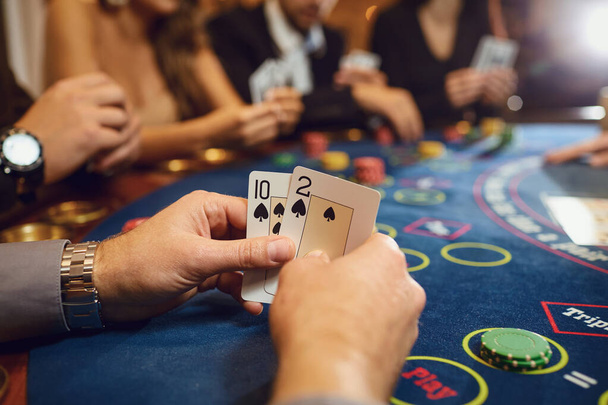 Hands of a poker player checking cards in a casino. - Φωτογραφία, εικόνα