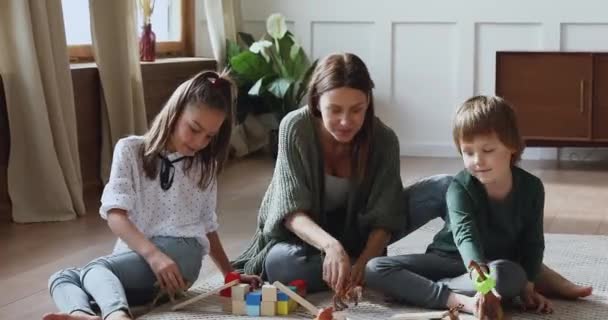 Huolehtiva äiti leikkii leluja lattialla lasten kanssa kotona
 - Materiaali, video