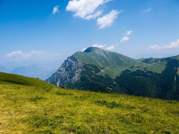 Monte Baldo dağı İtalya 'daki Garda Gölü kıyısındaki Malcesine tatil beldesinin arkasındadır. Dağın tepesine bir teleferik ulaşır ve tepesinde Alpaca ve koyunlarla birlikte dağlık çayırlar ve bir hediyelik eşya dükkanı vardır. Paragliderler rüzgarı yakalayıp aşağı atlarlar. - Fotoğraf, Görsel