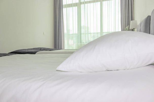 A bed with white sheets and pillows close up at a hotel appartment - Foto, afbeelding