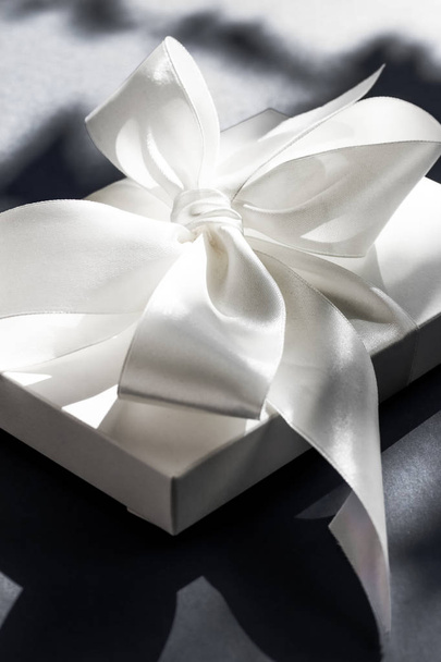Scatola regalo bianca vacanza di lusso con nastro di seta e fiocco su nero
  - Foto, immagini