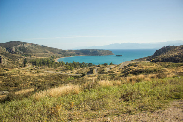 uitzicht op de top schilderachtig landschap gele rotsachtige heuvels met gebogen autoweg naar de Middellandse Zee kust in Peloponnesos half eiland in Griekenland   - Foto, afbeelding