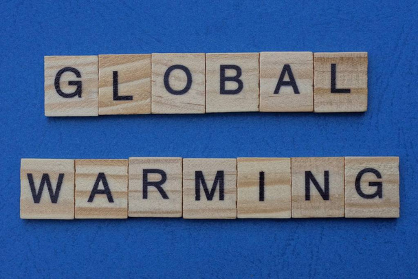 phrase global warming made from gray wooden letters lies on a blue table - Fotografie, Obrázek