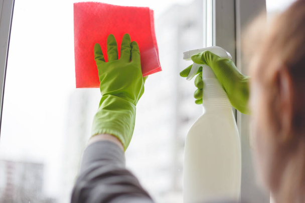 Women cleaning a window with spray and cloth. Close up - Foto, afbeelding