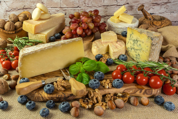 Sortiment sýrů s bylinkami, zeleninou, ořechy, hrozny a  - Fotografie, Obrázek