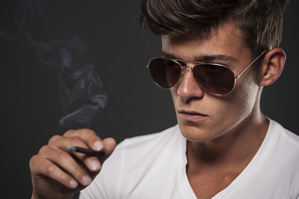 Focus young man with black cigarette - Foto, imagen